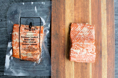 Kwee-Jack Fish Co. traditional wild caught smoked salmon on a serving board and in the ready to eat vacuum sealed pouch.