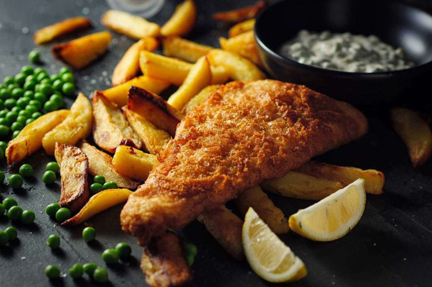 Wild Alaskan Cod fish and chips with tartar sauce, lemon and peas