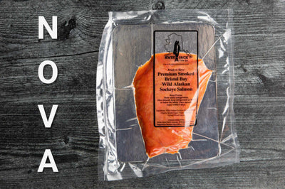 WILD CAUGHT NOVA STYLE SMOKED SALMON IN KWEE-JACK PACKAGING ON SERVING BOARD READY TO EAT.