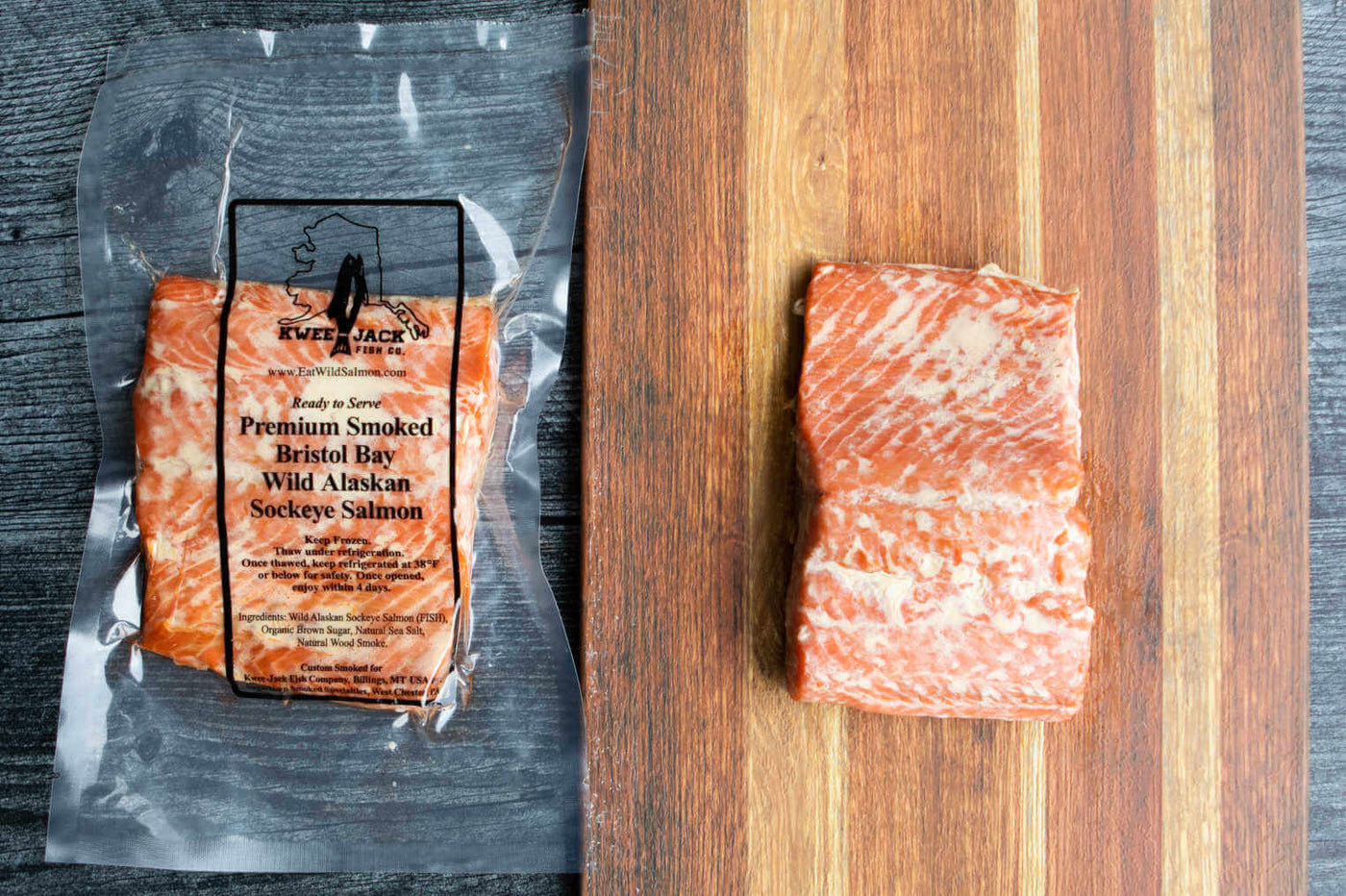Kwee-Jack Fish Co. Wild Caught Alaskan Traditional Smoked Salmon in vacuum packaging and on wooden cutting board.